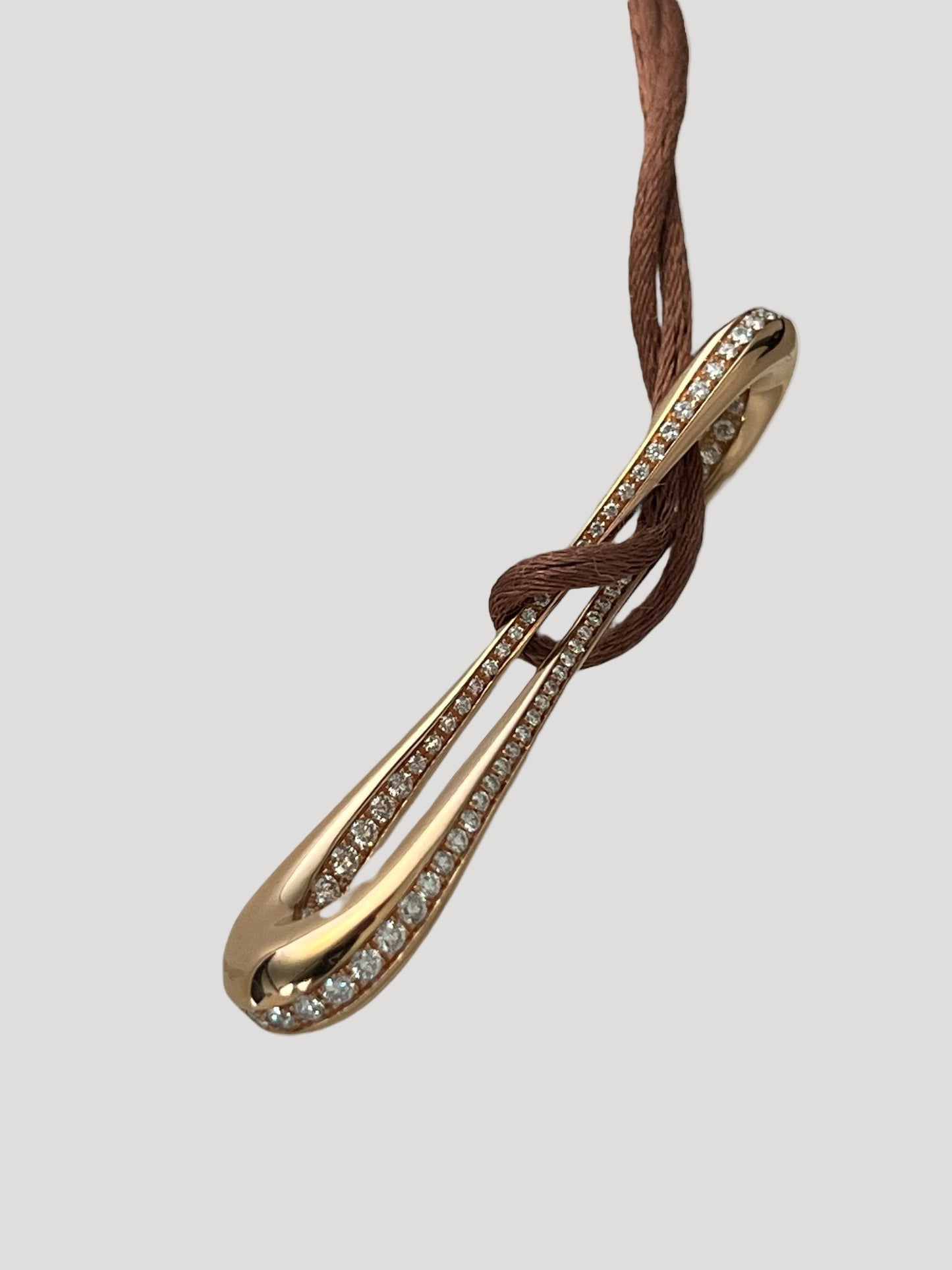 Infinity pendant in 18k rose gold set with brilliant-cut diamonds on brown satin lace