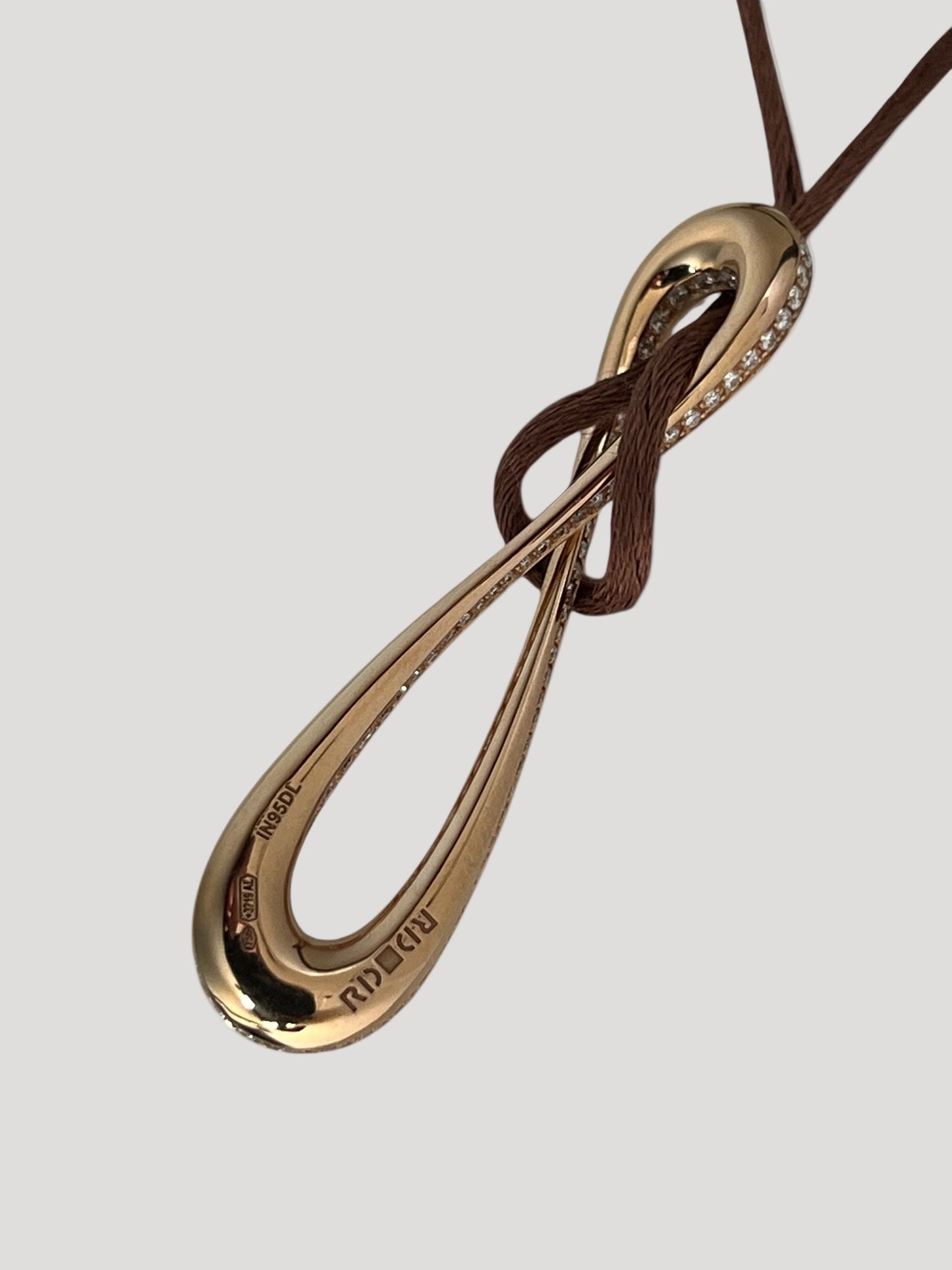 Infinity pendant in 18k rose gold set with brilliant-cut diamonds on brown satin lace