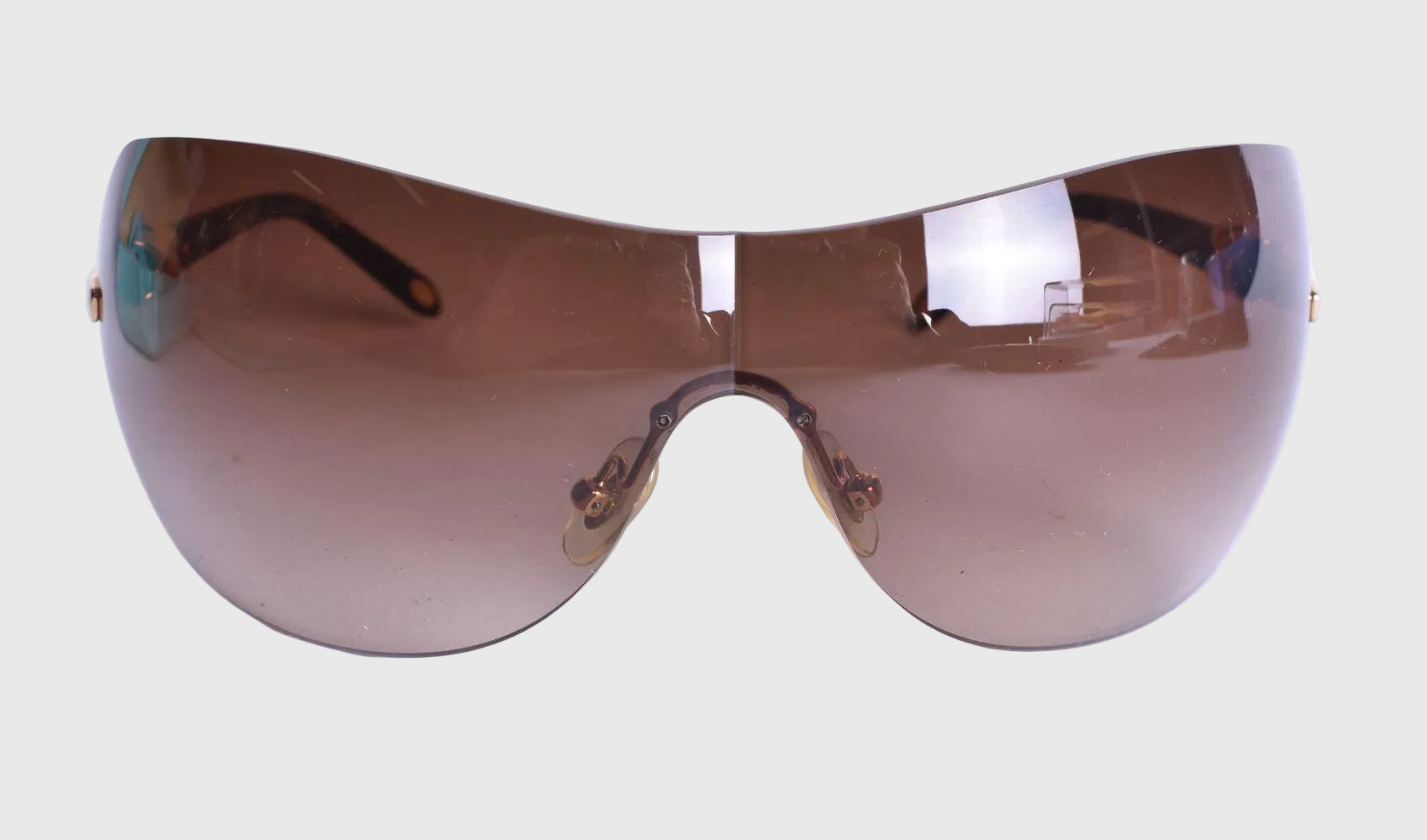 Sunglasses with a reflective brown lens on a white background