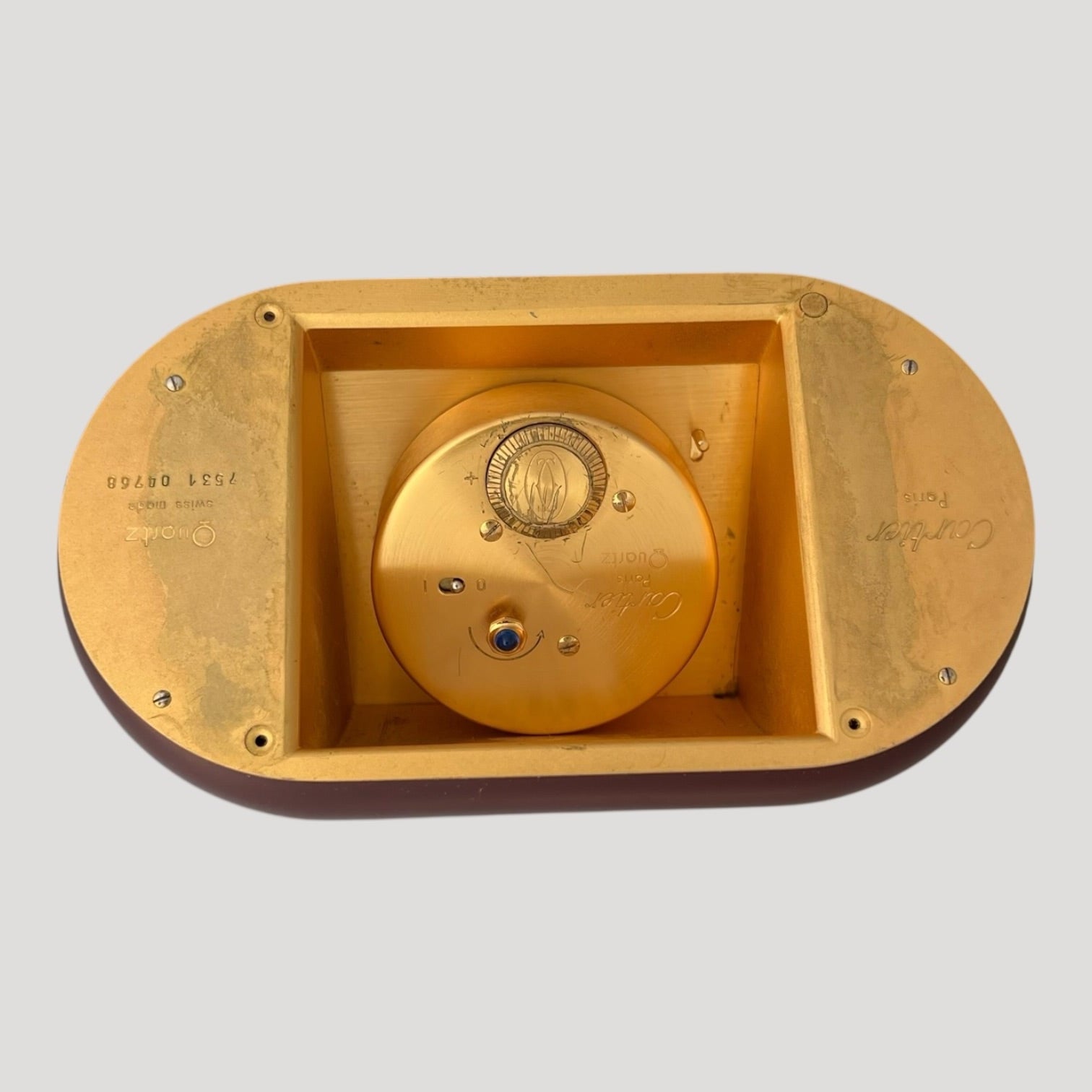 are Cartier, ' Accordion ' réf. 7531, desk clock in gilt metal and burgundy color lacquer