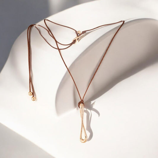 Infinity pendant in 18k rose gold set with brilliant-cut diamonds on brown satin lace