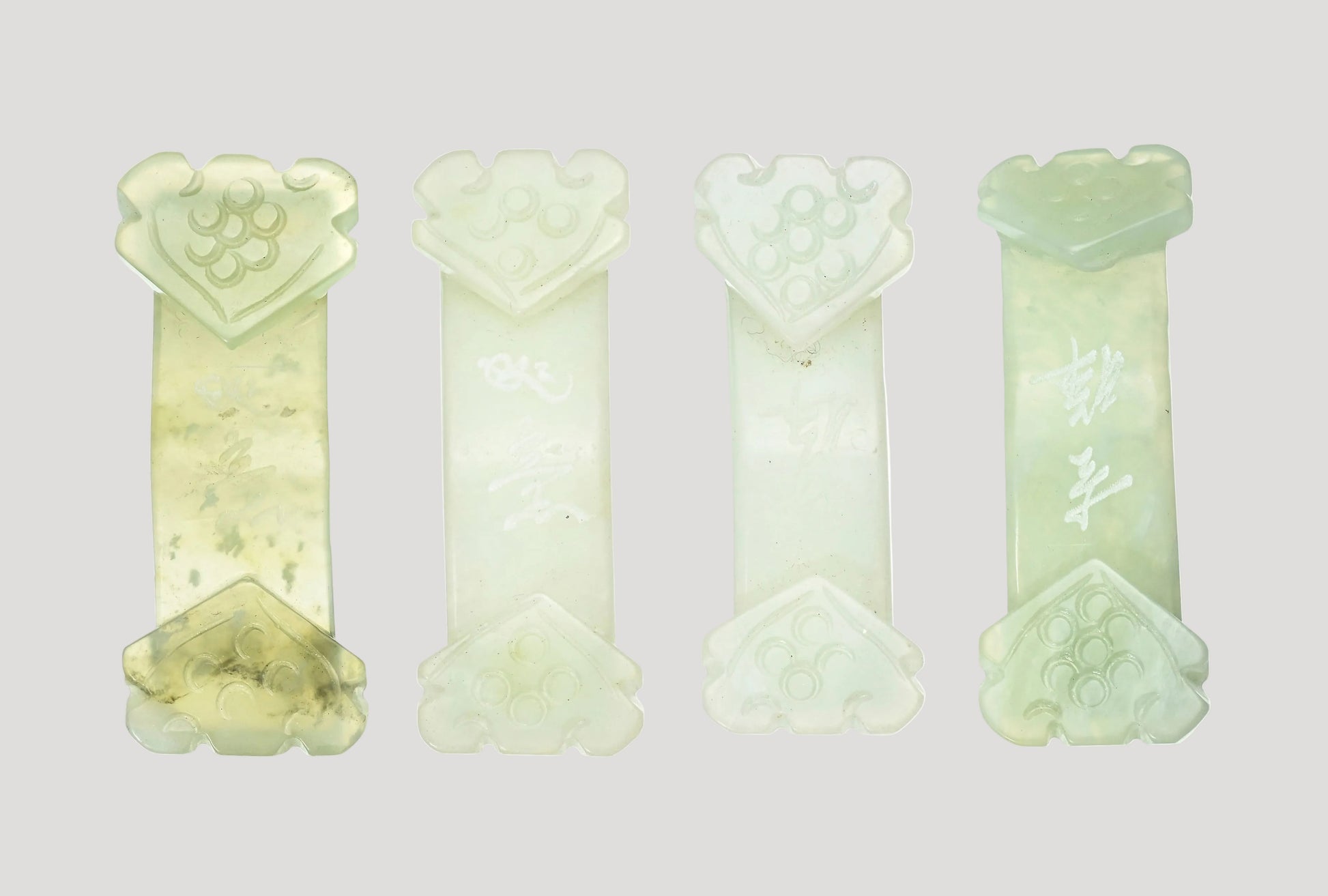 Set of 4 antique jade belt buckles, each adorned with two ruyi, with inscriptions