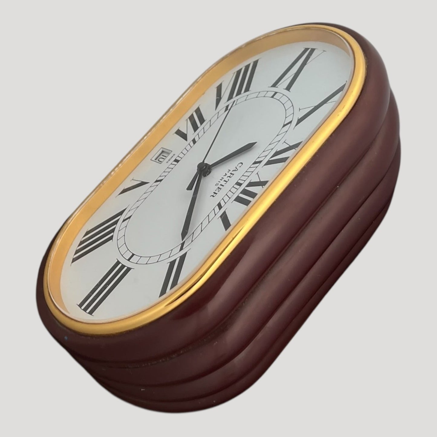 are Cartier, ' Accordion ' réf. 7531, desk clock in gilt metal and burgundy color lacquer
