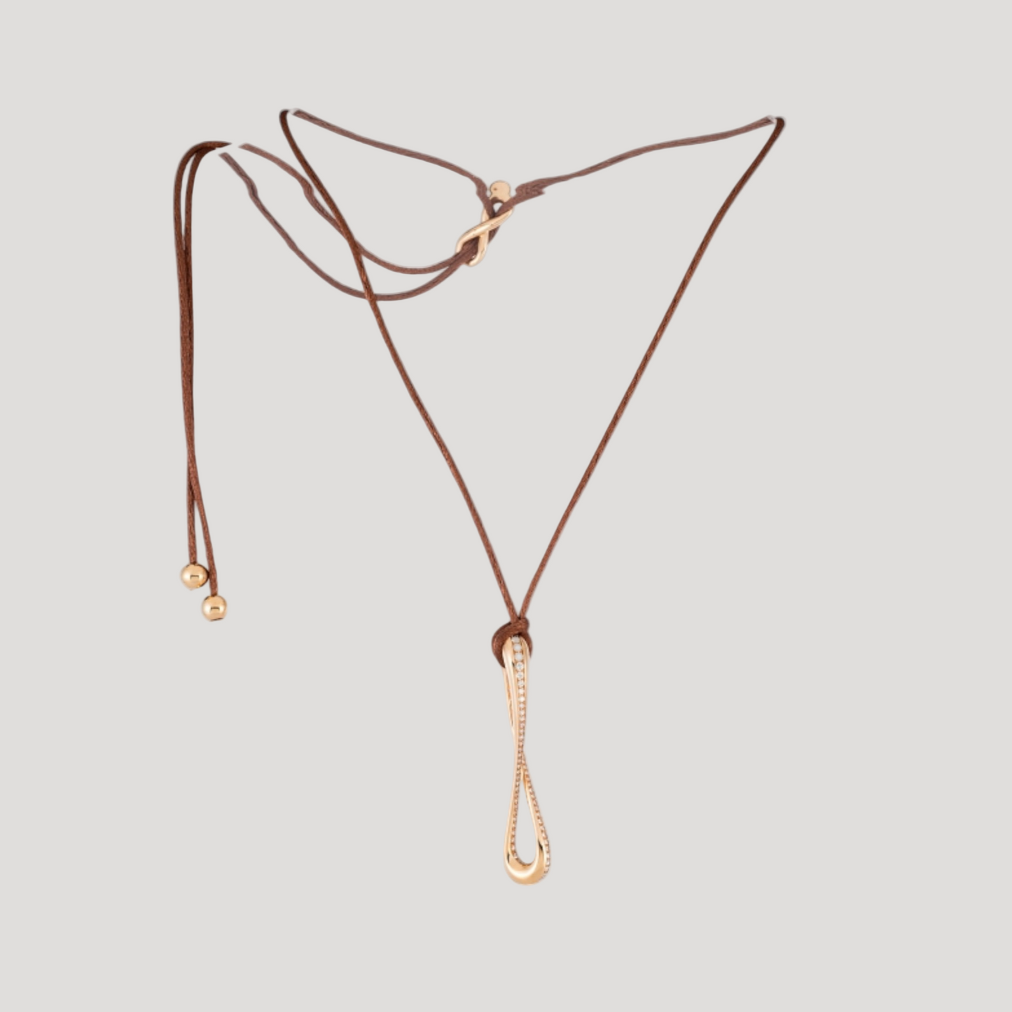 Infinity pendant in 18k rose gold set with brilliant-cut diamonds on brown satin lace